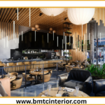 Here are a few options for ALT text, ranging in descriptiveness. Choose the one that best fits the specific visual content of the image: **Option 1 (Concise & Direct):** > Elegant restaurant interior in Muscat with comfortable seating and warm lighting. **Option 2 (Slightly More Descriptive):** > A welcoming and sophisticated restaurant interior design in Muscat, featuring plush seating, ambient lighting, and subtle Omani-inspired decor. **Option 3 (Focus on Atmosphere/Feeling):** > Cozy and inviting restaurant ambiance in Muscat, showcasing stylish furniture and soft illumination designed to encourage guests to linger. **Option 4 (If there are specific visual elements you want to highlight):** > A modern yet warm restaurant interior in Muscat, with deep-toned seating, intricate patterned wall accents, and strategic lighting creating an intimate atmosphere. **Option 5 (If the image shows a particular seating area):** > A comfortable dining nook within a Muscat restaurant, with plush seating, elegant table lamps, and decorative elements that invite relaxation. **Key considerations for choosing:** * **What is the most prominent feature in the image?** (e.g., seating, lighting, decor, a specific architectural element) * **What is the overall mood or feeling the image conveys?** (e.g., luxurious, cozy, modern, traditional) * **Does the image illustrate a specific design trend mentioned in your post?** **Why these are good ALT text:** * **Descriptive:** They tell a visually impaired user what the image depicts. * **Relevant:** They connect to the post's topic of restaurant interior design in Muscat. * **Concise:** They are not overly long, making them easy to read by screen readers. * **Keywords:** They include relevant keywords like "restaurant interior," "Muscat," and "design."
